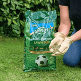 Person holding a bag of Gro-Sure multi-purpose lawn seed 